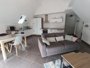 a living room with a couch and a table at Au pied des champs - T2 50m2 au calme in Blaesheim