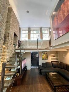 un soggiorno con divano e una scala in vetro di 4 floor Apartment in Covent Garden a Londra