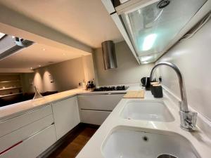 a white kitchen with a sink and a counter at 4 floor Apartment in Covent Garden in London