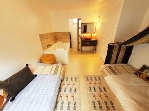 a small room with two beds and a sink at Dream of Mediterranean house, Jacuzzi, BBQ, Délices ensoleillés in Sartrouville