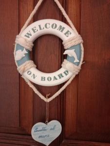 una corona de bienvenida a bordo en una puerta de madera en casetta al mare, en Sapri