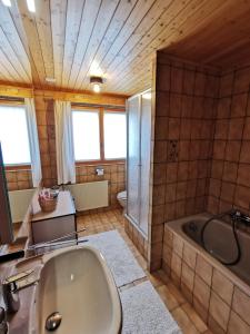 een grote badkamer met een bad en een wastafel bij CHALET HÜTTLE - authentisch, ruhig, mitten im grün in Grächen