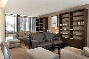 una sala de estar con sofás, sillas y un estante para libros. en Hotel Restaurant Weinebrugge, en Brujas
