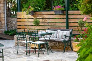 een patio met een tafel en stoelen en een bank bij Kastro Guesthouse in Ioannina