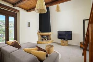 a living room with a couch and a fireplace at Giannis Place I in Áyios Vasílios