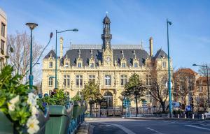 un grande edificio con una torre dell'orologio sopra di Studio de charme a Pantin