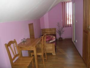 a dining room with a table and chairs and purple walls at Casa Sidor in Baile Felix +18 photos