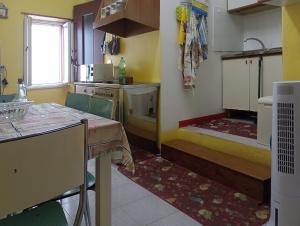 een keuken met een wastafel en een tafel in een kamer bij Casa TildePino davanti al fiume Temo in Bosa