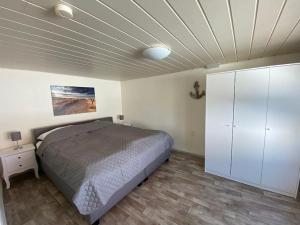 1 dormitorio con 1 cama y armario blanco en Ferienhaus mit Wasserblick auf der Insel Usedom, en Krummin