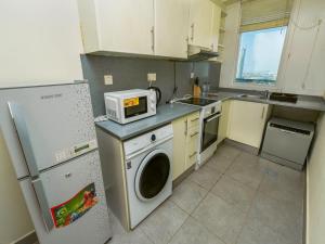 a kitchen with a washing machine and a microwave at 2 BHK @ Barsha Heights in Dubai