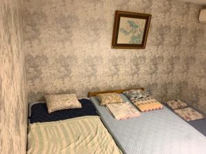 dos camas sentadas una al lado de la otra en un dormitorio en Tokyo Guest House 2020, en Tokio