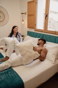 a man and a woman laying on beds at El Edén Casas Rurales con Piscina y Jacuzzi in Montánchez