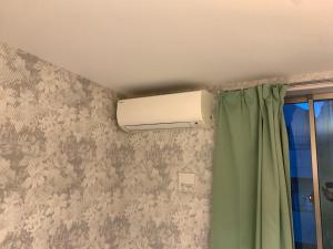 a bathroom with a heater and a green curtain at Tokyo Guest House 2020 in Tokyo
