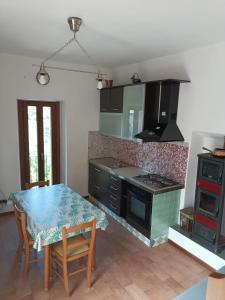 uma cozinha com uma mesa e um fogão forno superior em Casa Mia em Poggio Moiano