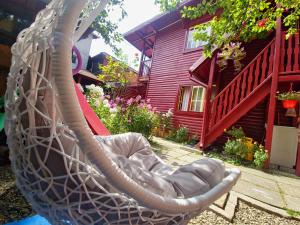 a swing in front of a red house at Casa Lav in Sinaia