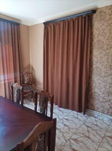 a room with a table and two chairs and a curtain at Sochiner Hotel in Vanadzor