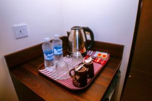 ein Tablett mit einem Wasserkocher und Wasserflaschen auf dem Tisch in der Unterkunft ِAfnan hotel in Aqaba