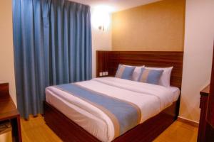 a bedroom with a large bed with blue curtains at ِAfnan hotel in Aqaba