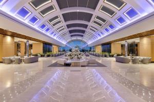 un grand hall avec des tables et des chaises dans un bâtiment dans l'établissement Miracle Resort Hotel, à Lara