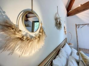 a mirror on a wall next to a bed at Domaine des moulins - La tour du moulin et son spa in Villy-le-Bouveret