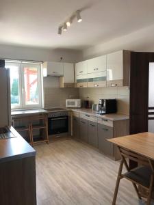 una cocina con armarios blancos y una mesa. en Charming individual house with a beautiful garden and self checkin en Satu Mare