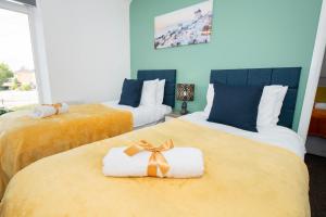 Versatile Cozy & Spacious Comfort Hull Apartments في هال: غرفة نوم بسريرين عليها مناشف