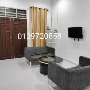 ein Wohnzimmer mit 2 Sofas und einem TV in der Unterkunft KUALA TERENGGANU GUESTHOUSE-FREE WIFI-NEAR NASI DAGANG ATAS ToL-UNIT A-1 BILIK AIRCOND 2 BILIK KIPAS in Kuala Terengganu