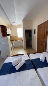 two beds in a kitchen with towels on them at Overview Apartments Saranda in Sarandë