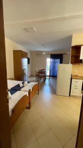 a room with two beds and a kitchen with a table at Overview Apartments Saranda in Sarandë