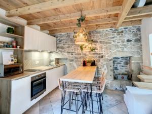 a kitchen with a wooden table and chairs at Domaine des moulins - La tour du moulin et son spa in Villy-le-Bouveret