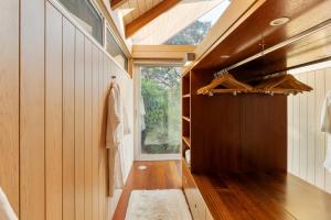 a room with wood paneled walls and a window at The Glasshouse in Whangarei Heads