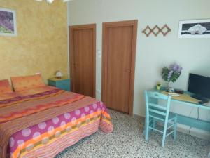 a bedroom with a bed and a desk with a computer at Affittacamere Dolce Miele in Foligno