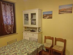 a dining room with a table and chairs and a cabinet at Affittacamere Dolce Miele in Foligno +5 photos