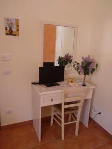 a desk with a computer on it with a mirror at Affittacamere Dolce Miele in Foligno