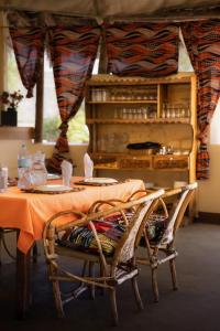 a table with two chairs and a table with a table cloth at Lake Natron Maasai giraffe eco Lodge and camping in Mtowabaga