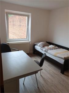 een kamer met een bed, een tafel en een raam bij Monteurwohnung/ Ferienwohnung Weißenfels/ Sachsen - Anhalt in Weißenfels