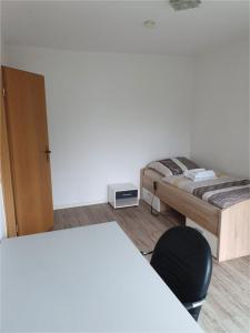 um quarto com uma cama e uma cadeira em Monteurwohnung/ Ferienwohnung Weißenfels/ Sachsen - Anhalt em Weißenfels