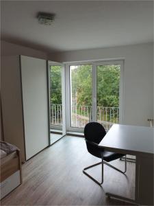 een kamer met een tafel, een stoel en ramen bij Monteurwohnung/ Ferienwohnung Weißenfels/ Sachsen - Anhalt in Weißenfels