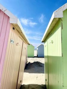 una fila de coloridas cabañas de playa en una playa en Joli T4 au coeur de Berck-Plage, en Berck-sur-Mer