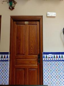 una puerta de madera en la esquina de una habitación en Hostal Infantes, en Toledo