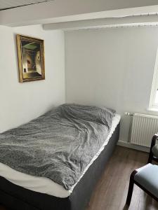 a bed in a room with a picture on the wall at Sunbjerre B&B in Lille Dalby