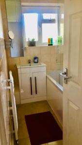 a bathroom with a sink and a tub and a window at City location- 2 bedroom apartment in London