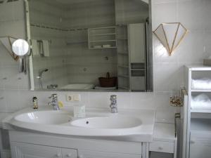 a white bathroom with a sink and a mirror at Hotel Kürschner in Kötschach