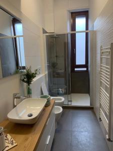 uma casa de banho com 2 WC, um lavatório e um chuveiro em Bilocale 5 min Stazione Centrale em Milão