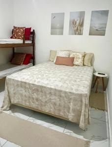 a bedroom with a bed with pillows on it at Suítes Recanto Monte trigo in São Francisco do Sul