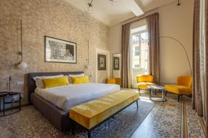 um quarto com uma cama king-size e almofadas amarelas em Grand Universe La Residenza em Lucca