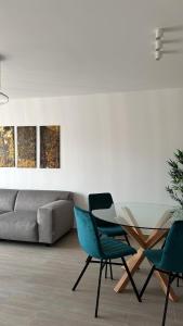 a living room with a glass table and two chairs at Kronburg 95-12 in Braşov
