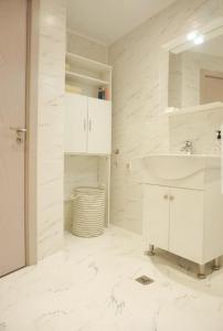 Baño blanco con lavabo y espejo en sea view hygge - Quiet residential apartment, en Kavarna