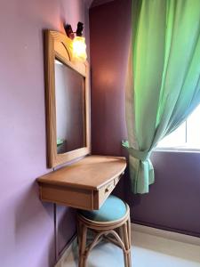 een badkamer met een wastafel met een spiegel en een kruk bij Glory beach private PD in Port Dickson