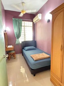 a bedroom with a blue bed and a window at Glory beach private PD in Port Dickson